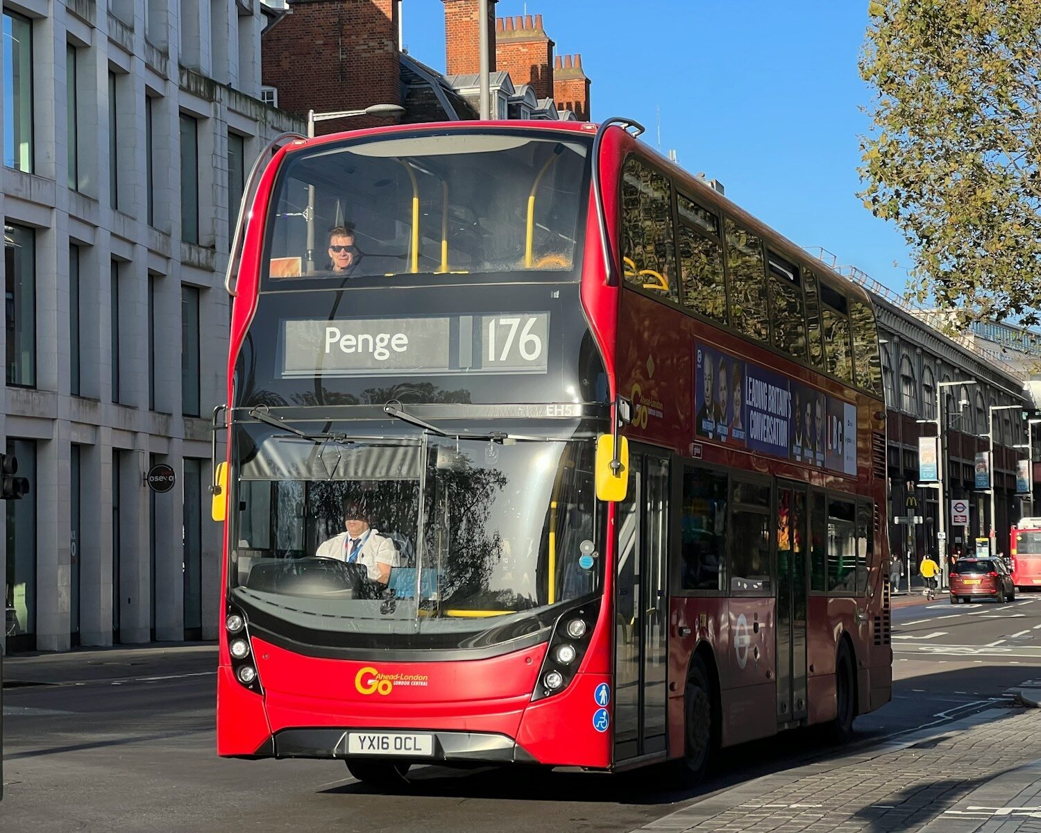 a red double decker bus driving down a street